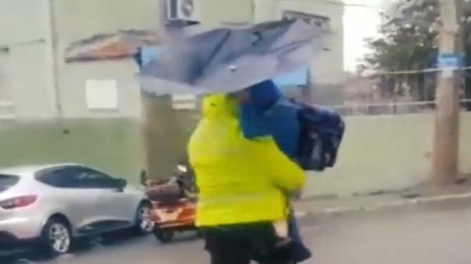Polis fırtınada yolun karşısına geçemeyen öğrenciyi kucağında taşıdı